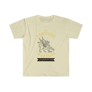 K&ouml;nnte beinhalten: Ein beiges T-Shirt mit einem schwarzen und goldenen Grafikdesign. Die Grafik zeigt einen gefl&uuml;gelten L&ouml;wen mit dem Text "1834 Tartaria mud flood championship".