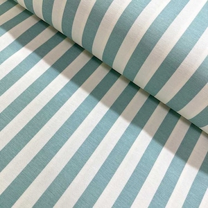 May include: Close-up of a fabric roll featuring a repeating pattern of diagonal stripes. The stripes alternate between a soft, muted teal and white. The fabric appears to be a woven material, possibly cotton or linen, with a slight texture.