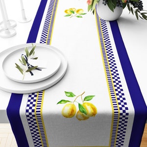 Peut inclure: Un chemin de table blanc avec une bordure à carreaux bleus et jaunes. Le chemin de table présente un motif aquarelle de citrons sur une branche.