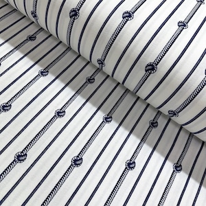 May include: White fabric with navy blue stripes and rope knots. The fabric is folded in half, showing the pattern on both sides.
