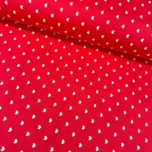 May include: Red fabric with a white heart pattern.