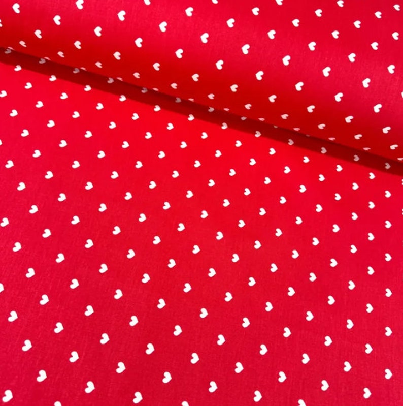 May include: Red fabric with a white heart pattern.