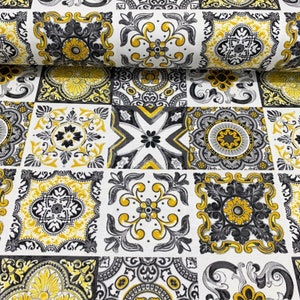 May include: A white fabric with a repeating pattern of black and yellow geometric tiles. The tiles feature intricate floral designs and are arranged in a grid pattern.