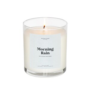 May include: A clear glass candle jar with a white soy coconut wax candle inside. The label reads "Morning Rain" and "Soy Coconut Wax Candle".