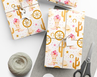 May include: Three wrapped gifts with a white background and a repeating pattern of cowboy boots, hats, cacti, and wagon wheels. The gifts are tied with twine and have star-shaped tags. A ball of twine, scissors, and blank tags are also visible.