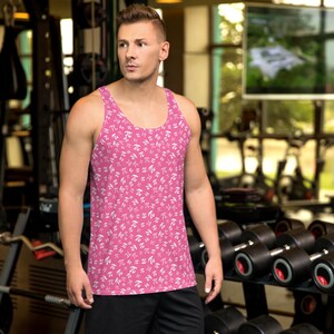 May include: A pink tank top with a white pattern of the mathematical symbol pi. The tank top is being worn by a person in a gym setting.