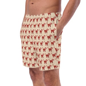 May include: Beige shorts with a repeating pattern of red monkeys.
