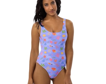 May include: A one-piece swimsuit with a light purple background and a colorful sea life pattern. The pattern includes orange fish, yellow suns, pink starfish, and green seaweed. The swimsuit has a scoop neck and a high-cut leg.