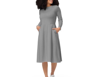 May include: A gray long-sleeved midi dress with a round neckline and pockets. The dress has a slightly flared skirt.