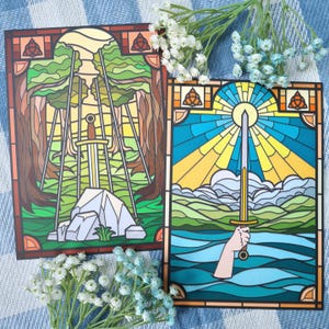 May include: Two stained glass panels depicting a sword in different settings. The first panel shows a sword standing on a rock in a green forest with a sun shining through the trees. The second panel shows a sword in a body of water with a sun shining above it.
