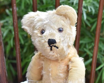 ヴィンテージの小さなライトベージュのモヘアのテディベア。ピンクの