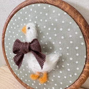 Close-up felt goose bow – needle felt animal, baby shower present detail