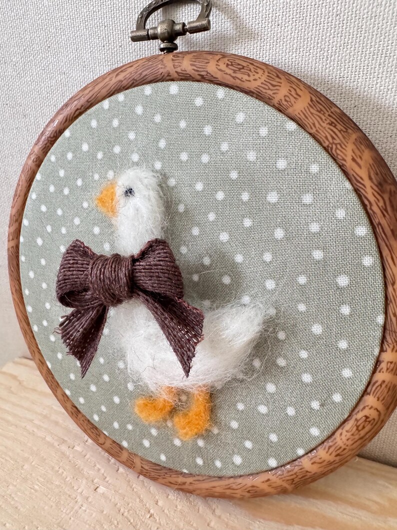 Close-up felt goose bow – needle felt animal, baby shower present detail