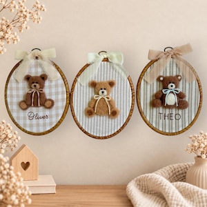 May include: Three oval embroidery hoops featuring felt teddy bears. The left hoop has a beige gingham background with the name Oliver. The center hoop has a striped background. The right hoop has a striped background with the name THEO.