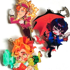 May include: Three colorful acrylic charms featuring anime-style characters. One character wears a pink military-style uniform, another holds a gun under a red umbrella, and the third wears glasses and holds a book.