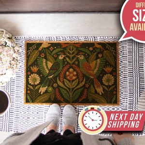 May include: A doormat featuring a colourful floral and bird design. The doormat is made of coir and has a natural brown colour. The doormat is placed on a white and blue patterned rug. The text "Different Sizes Available" is in a red speech bubble in the top right corner of the image. The text "Next Day Shipping" is in a red circle in the bottom right corner of the image.