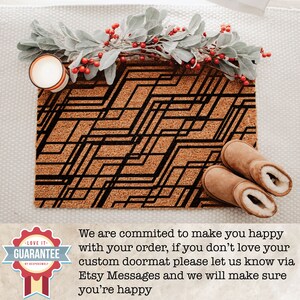 May include: A brown coir doormat with a black geometric pattern. The text "LOVE IT - GUARANTEE" is on a white circle with a red border. The text "OF RESPONSIBILITY" is in smaller font below the guarantee text.