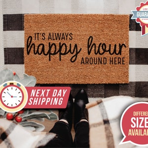 May include: A brown coir doormat with the text "IT'S ALWAYS happy hour AROUND HERE" in black lettering.
