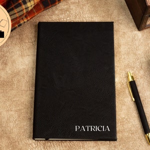 May include: Black leather-bound journal with the name "PATRICIA" embossed in silver lettering.