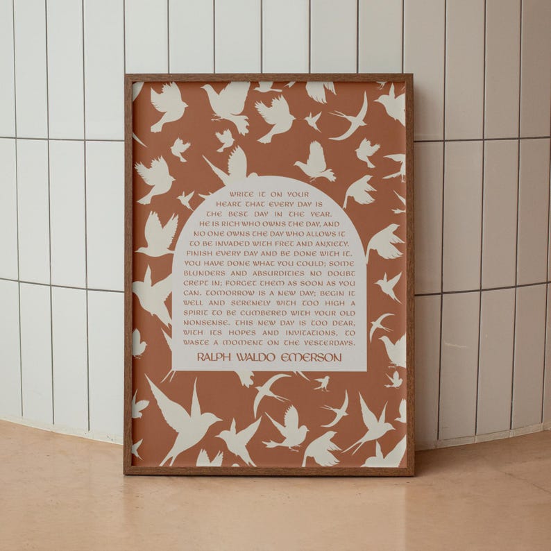 May include: A framed art print with a terracotta background and white bird silhouettes. The print features a quote by Ralph Waldo Emerson. The frame is a dark brown colour.