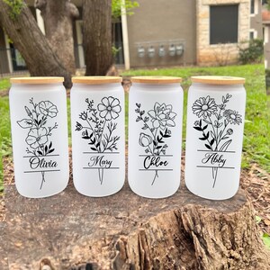 May include: Four white frosted glass canisters with bamboo lids and black floral designs. Each canister has a name printed on the front: Olivia, Mary, Chloe, and Abby.