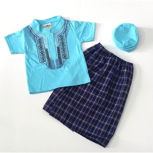 May include: A light blue short-sleeved shirt with an embroidered design, a blue and black plaid skirt, and a light blue hat. The shirt has a button closure at the neck.