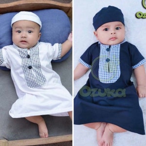 Pode incluir: Dois bebês vestindo roupas quadriculadas brancas e azuis com chapéus combinando. O bebê à esquerda está vestindo uma roupa branca com um painel quadriculado azul e branco, enquanto o bebê à direita está vestindo uma roupa azul marinho com um painel quadriculado azul e branco.