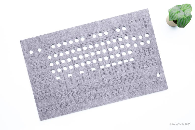 May include: A gray felt panel with cut-out shapes resembling a sound mixing board. The panel has numerous circular and rectangular openings, along with slider-like cutouts. A small potted plant is in the upper right corner. The text "WaveTable 2025" is in the lower right corner.