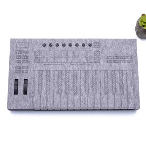 May include: A gray felt keyboard controller with 16 pads, 16 keys, and two knobs. The controller is designed to look like a vintage keyboard.