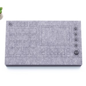 Op de afbeelding: Een grijs viltpad met een bedrukt ontwerp van een muziekproductiecontroller. Het pad heeft een raster met knoppen, een scherm en een knop.
