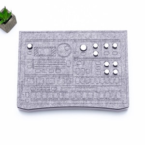 May include: A grey felt mouse mat shaped like a vintage synthesiser with white buttons and knobs.