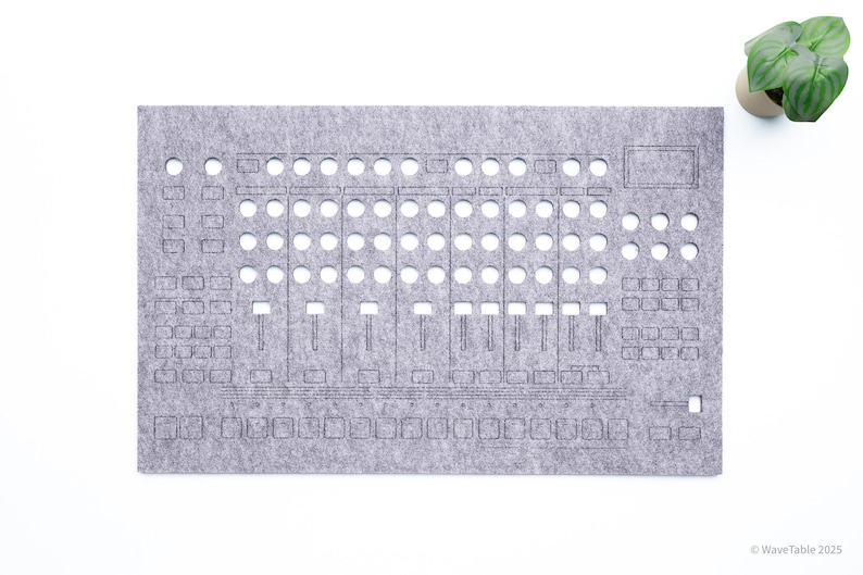May include: A gray felt panel with cut-out holes and etched lines, resembling a control panel. The design includes various button and slider shapes. A small potted plant is in the upper right corner. The text "WaveTable 2025" is in the lower right corner.