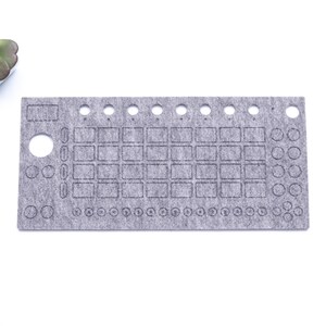 Peut inclure: Un tapis en feutre gris avec des découpes pour des boutons, des boutons et des curseurs. Le tapis est conçu pour être utilisé avec un synthétiseur ou d'autres équipements de musique électronique.
