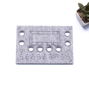 Peut inclure: Un tapis en feutre gris avec des découpes pour un synthétiseur, y compris une découpe rectangulaire pour un écran et cinq découpes rondes pour des boutons.