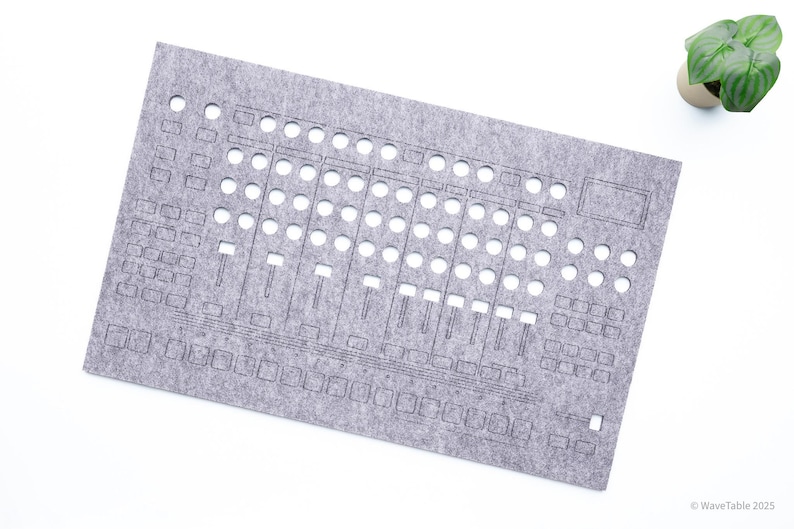 May include: A gray felt panel with cut-out shapes resembling a sound mixing console. The panel has numerous circular and rectangular openings, along with slider-shaped cutouts. A small potted plant is in the upper right corner. The text "WaveTable 2025" is in the lower right corner.