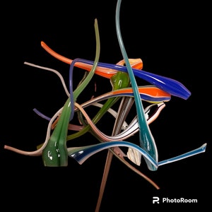 May include: Abstract glass sculpture with a complex arrangement of colorful, curved glass rods. The sculpture features shades of blue, green, orange, and white against a black background. The glass rods are twisted and intertwined, creating a dynamic and visually engaging artwork.