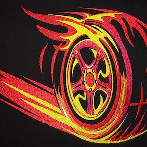 Peut inclure: Broderie d'un pneu avec des flammes, en rouge, jaune et rose sur un fond noir.