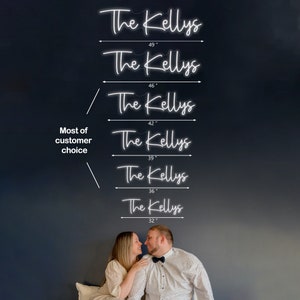 May include: A white neon sign with the text "The Kellys" in a cursive font. The sign is shown in six different sizes, ranging from 32 inches to 49 inches. The sign is displayed on a dark grey wall.