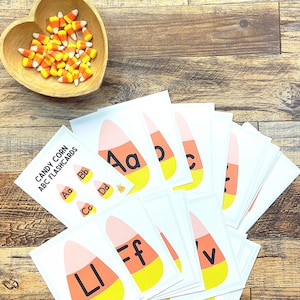 Puede incluir: Un conjunto de tarjetas de memoria de alfabeto imprimibles con forma de maíz dulce con las letras A a V. El título de las tarjetas de memoria es "Candy Corn ABC Flashcards".
