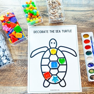 May include: A printable sea turtle craft activity with the text "Decorate the Sea Turtle". The craft includes a black outline of a sea turtle with spaces to decorate with buttons, pom-poms, or other craft supplies. The image also shows a variety of craft supplies in clear containers, including buttons, pom-poms, and seashells.