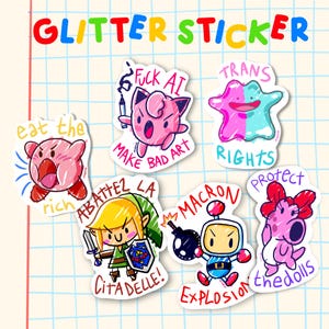 Op de afbeelding: Een verzameling van zes glitterstickers met stripfiguren en de teksten "eat the rich", "FUCK AI MAKE BAD ART", "TRANS RIGHTS", "ABATTEZ LA CITADELLE", "MACRON EXPLOSION" en "PROTECT the dolls" op een geruite achtergrond.