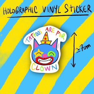 May include: Holographic vinyl sticker featuring a cartoon clown face with a blue cat-like head, a star eye, and the text "Tattoos are for Clown". The sticker is approximately 7cm in height, with a yellow and blue striped background.