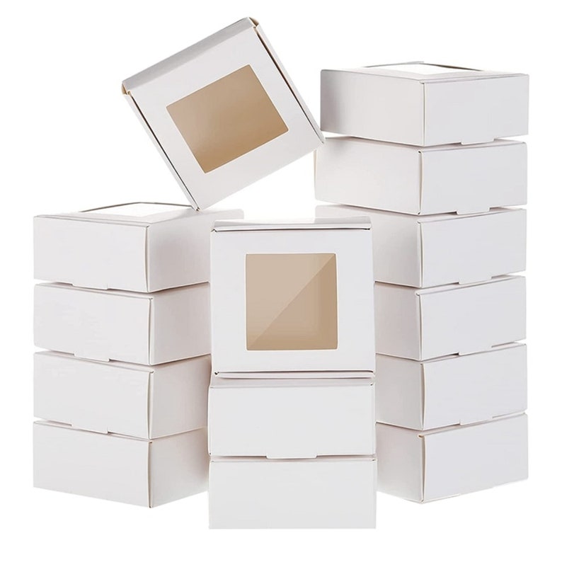 Peut inclure: Dix bo&icirc;tes en carton blanc avec une fen&ecirc;tre transparente sur le devant. Les bo&icirc;tes sont toutes de la m&ecirc;me taille et sont dispos&eacute;es en forme de pyramide.