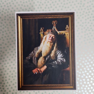 May include: A framed portrait of a man with a long white beard and a crown, sitting on a throne. The portrait is painted in a realistic style and has a dark background.