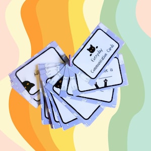May include: A set of purple cards with black and white cat illustrations. The cards are labeled "Everyday Communication Cards".