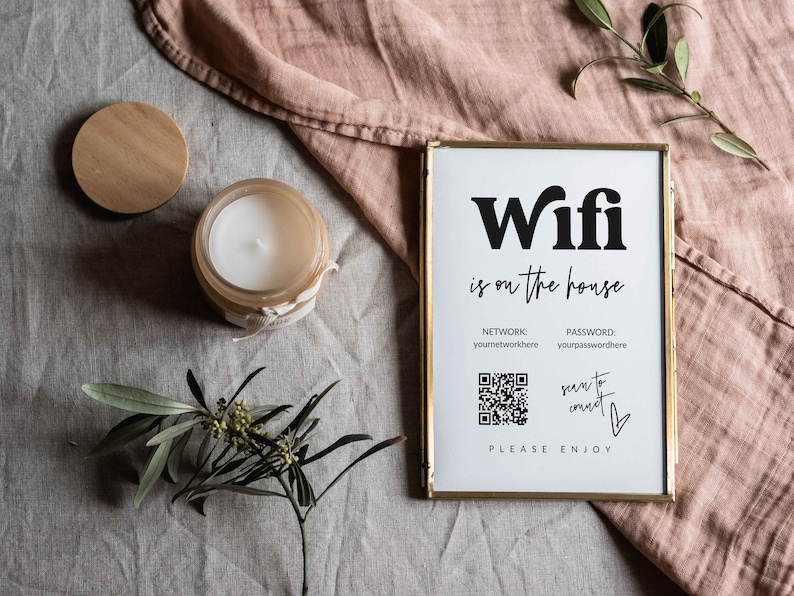 May include: A framed sign with the text "Wifi is on the house" and a QR code for connecting to the network. The sign also includes the text "NETWORK: youmetworkhere PASSWORD: yourpasswordhere" and "scan to connect".