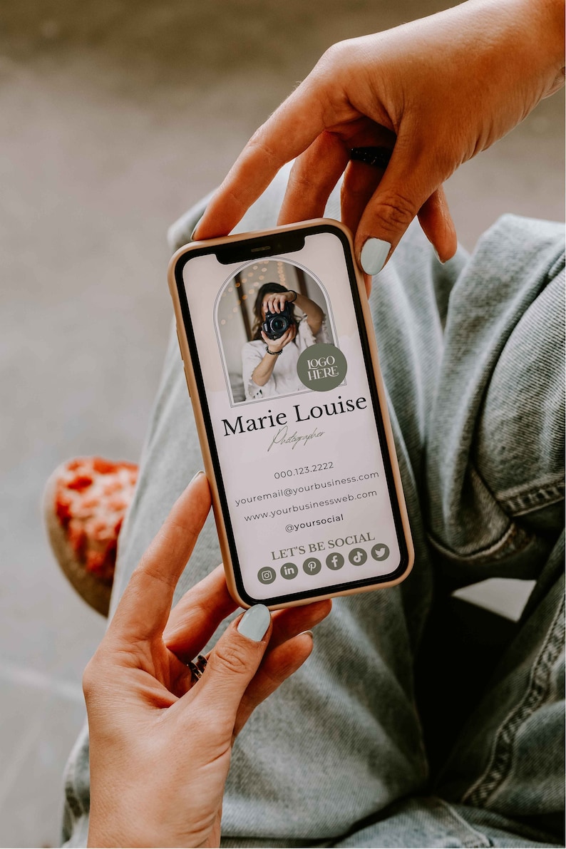 May include: A mobile phone displaying a business card for a photographer named Marie Louise. The card features a photo of the photographer, contact information, and social media icons. The text on the card reads "LOGO HERE", "Marie Louise", "Photography", "000.123.2222", "youremail@yourbusiness.com", "www.yourbusinessweb.com", "@yoursocial", "LET'S BE SOCIAL".