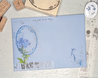 May include: A blue envelope with a floral stamp and the text "You good in all things."  The envelope is decorated with a floral design and a bird stamp.