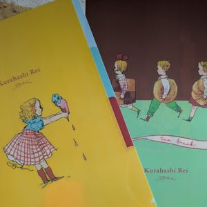 May include: Two plastic file folders with illustrations. The yellow folder features a girl holding an ice cream cone, with the text "Kurahashi Rei". The green folder has children with donuts and the words "tea break" and "Kurahashi Rei".
