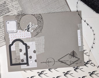 May include: A gray envelope with various decorative elements, including a black and white bird, a black and white butterfly, and a black and white grid pattern. The envelope has the text "HEART & SOUL" written on it.